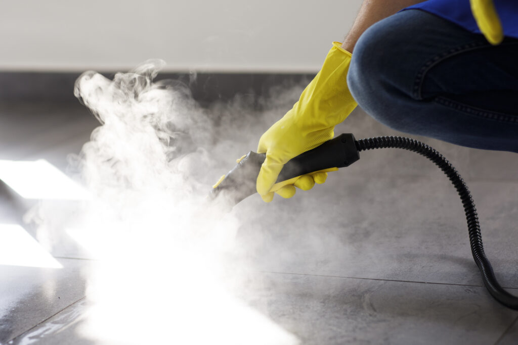 professional cleaning service person using steam cleaner office
